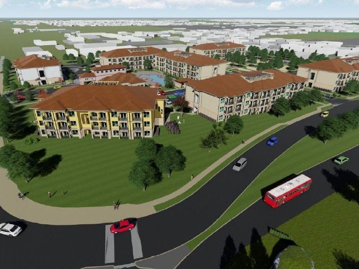 Rendering of several three-story multifamily buildings surrounding by grass and trees with rendered vehicles driving by on a nearby road.